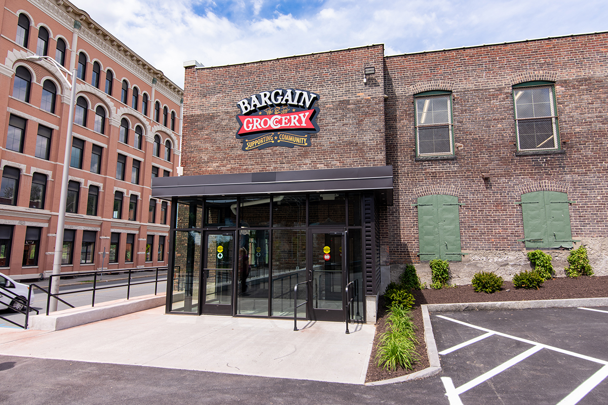 Bargain Grocery's new glass vestibule with surrounding landscaping.