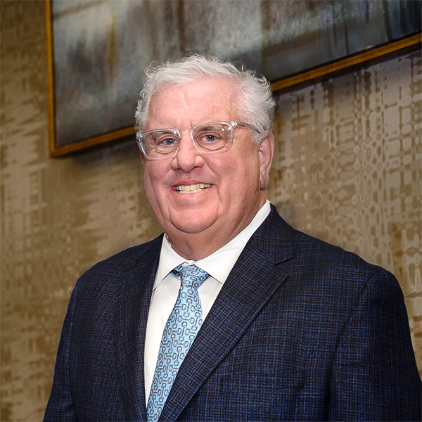 Matt Bette, Member of Bette & Cring, smiling while wearing a blue suit with a blue tie.